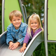 Kinder beim Rutschen auf einem Spielplatz