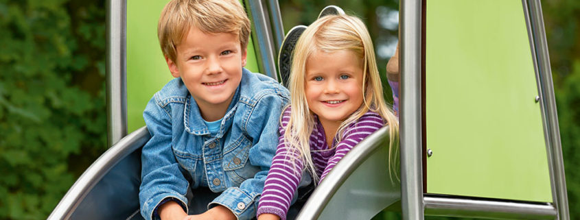 Kinder beim Rutschen auf einem Spielplatz